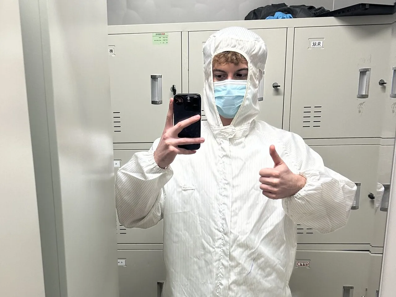 Me in a full cleanroom suit, mask and shoe covers, giving a thumbs up