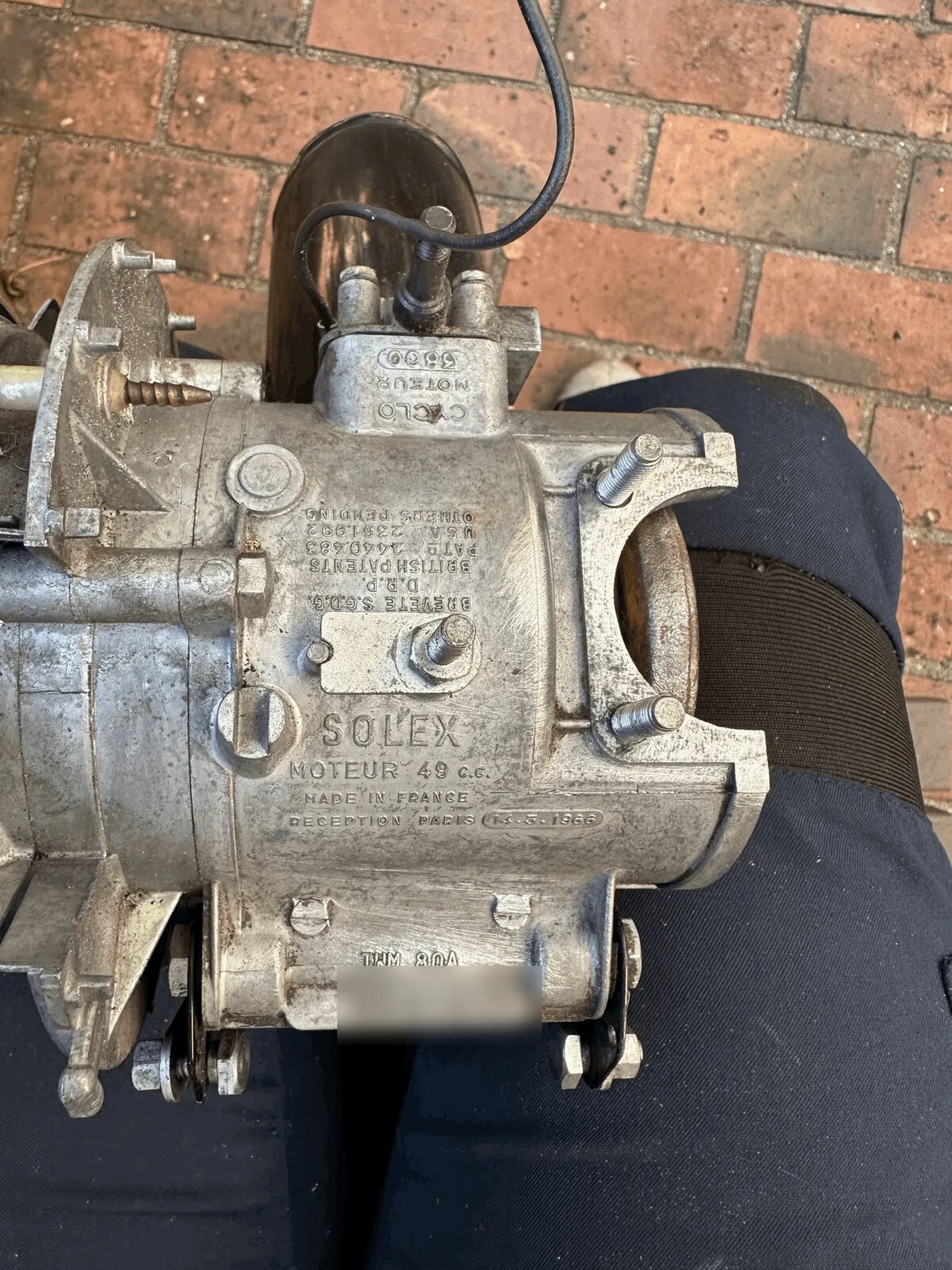 The bare aluminium Solex engine casing, stamped Solex Moteur 49 cc, Made in France, on my lap before the rebuild