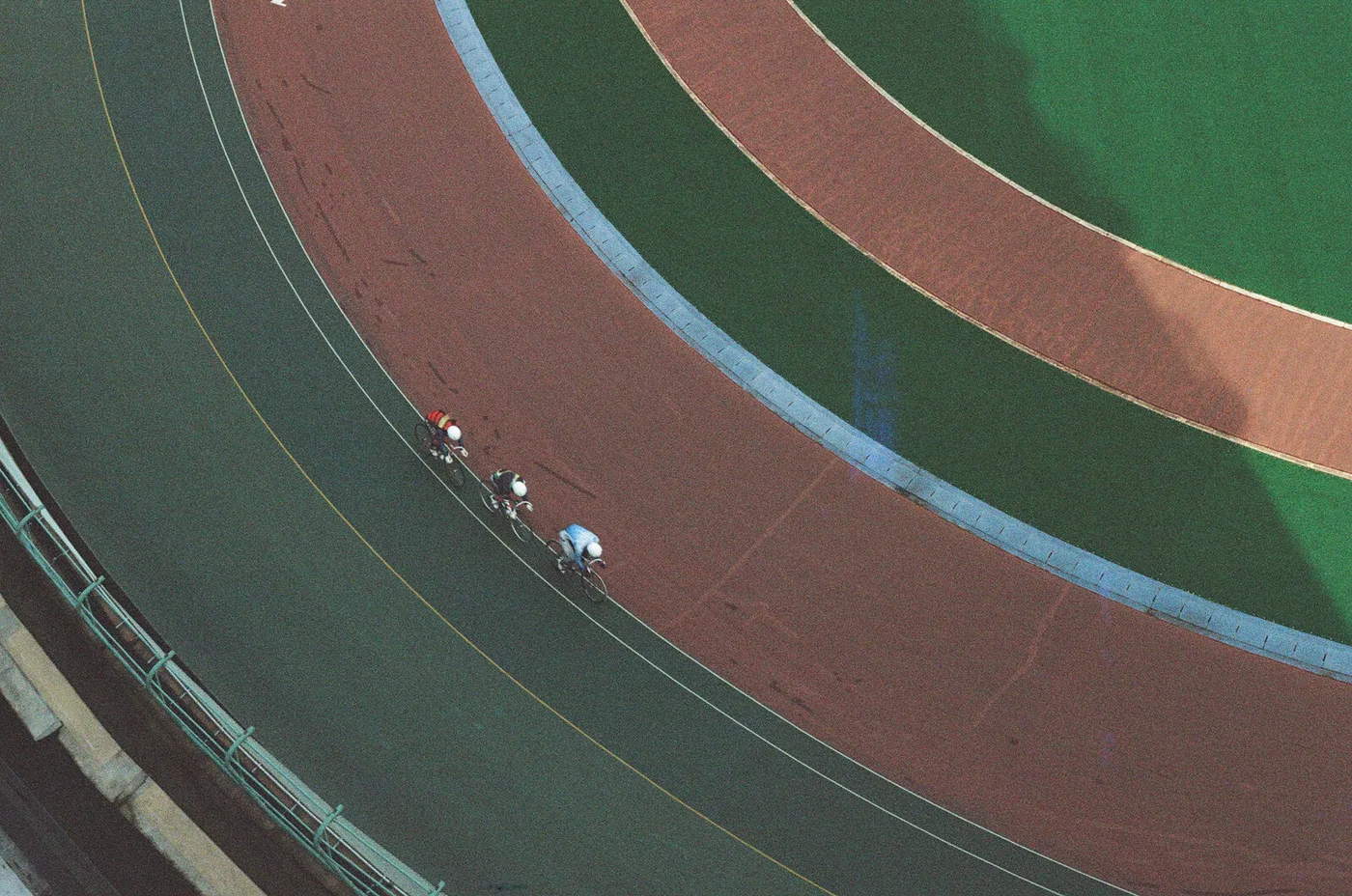Cyclists riding a velodrome track, seen from above