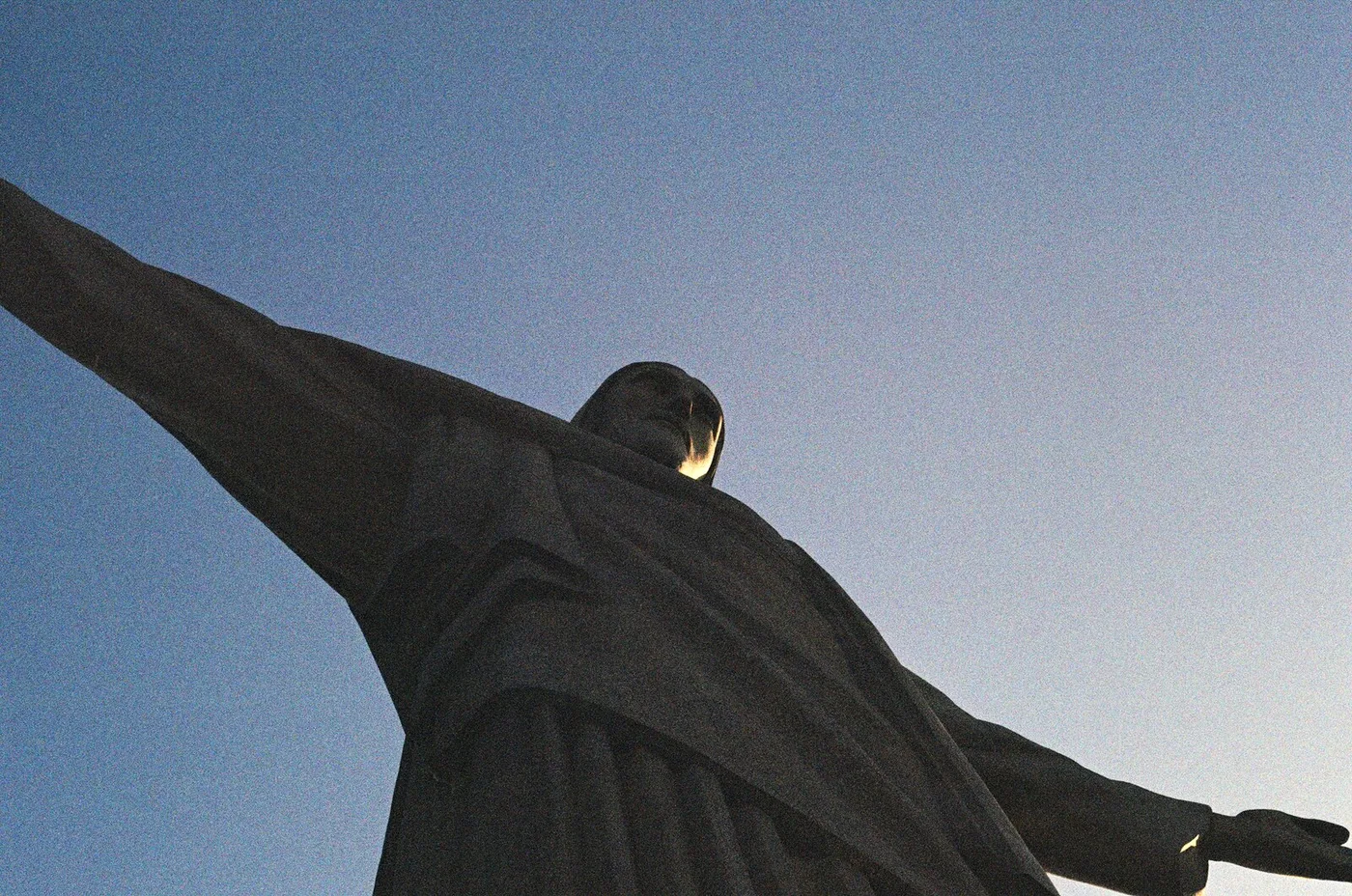 Christ the Redeemer in Rio de Janeiro, seen from below against a dusk sky