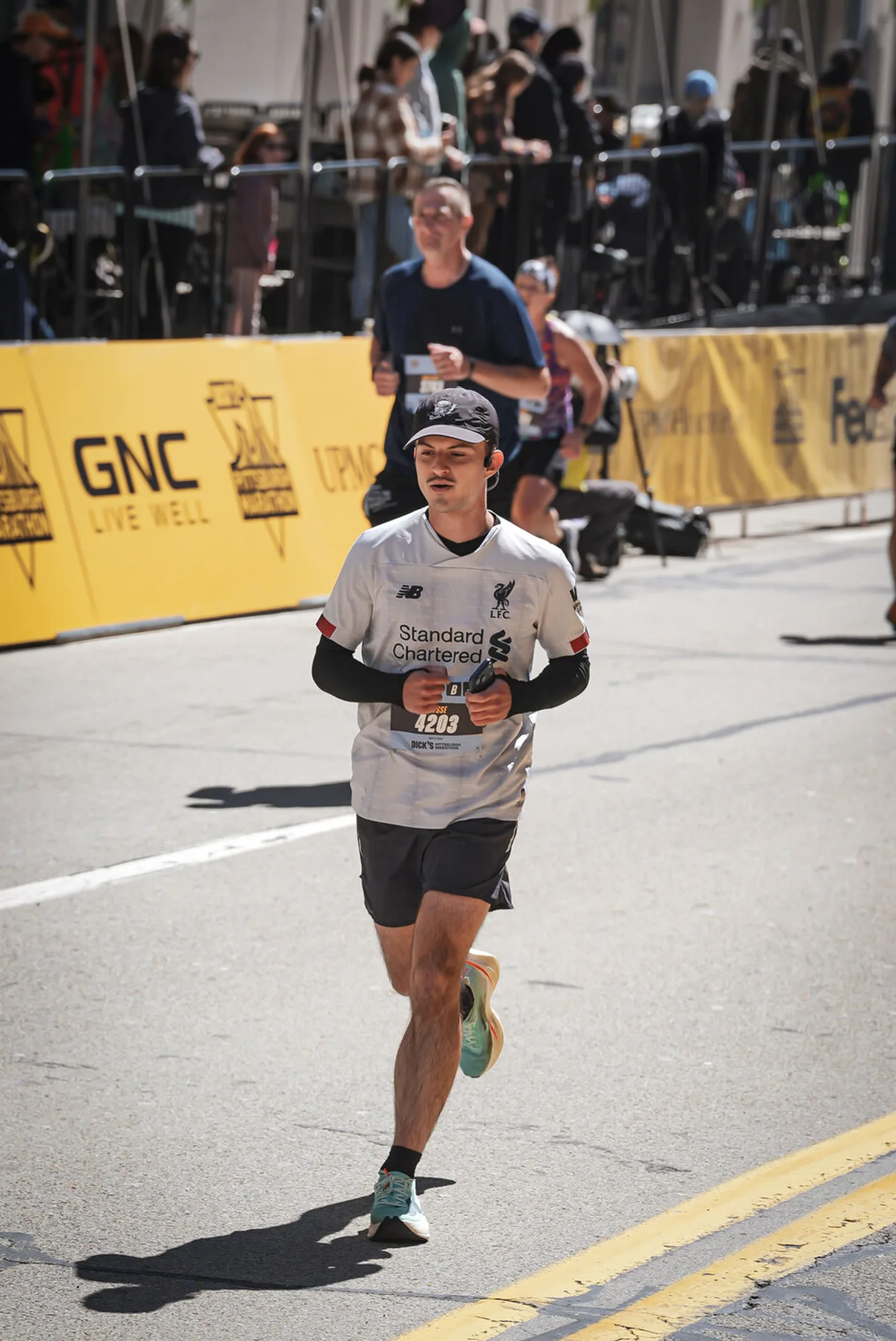 Me running the Pittsburgh Marathon in a white Liverpool shirt, bib 4203